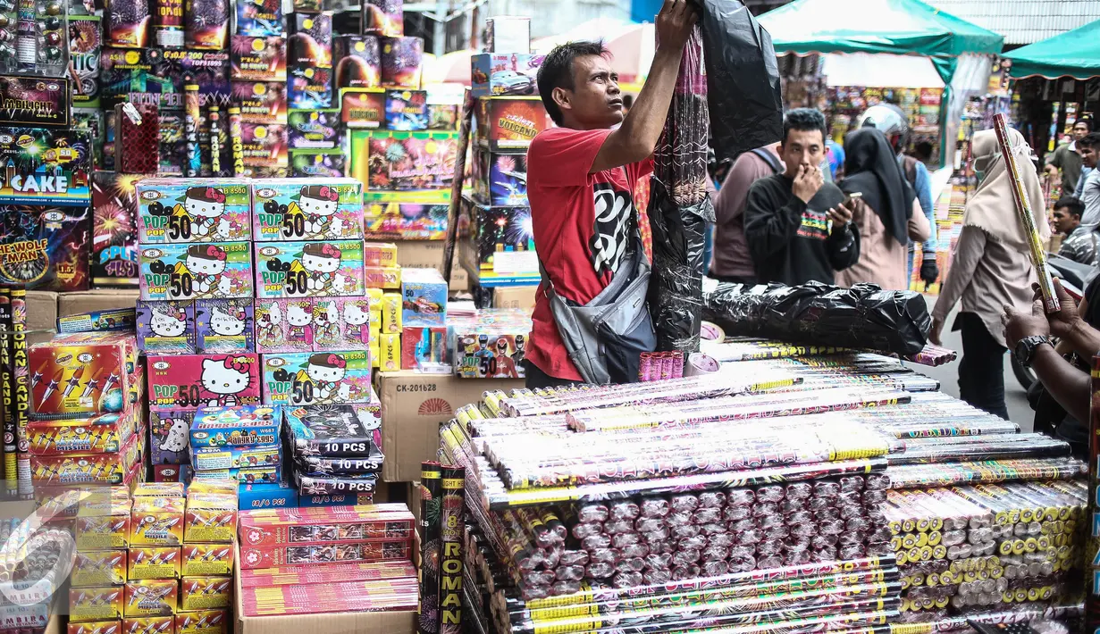 Seorang pedagang membungkus petasan yang sudah laku di Pasar Asemka, Jakarta, Selasa (27/12). ). Biasanya, perayaan tahun baru memang identik dengan menyalakan petasan dan pesta kembang api. (Liputan6.com/Faizal Fanani)