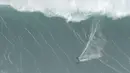 Peselancar Michelle des Bouillons dari Brasil mengendarai ombak selama kompetisi selancar ombak besar Nazare Tow Challenge di Praia do Norte, atau Pantai Utara, di Nazare, Portugal, Kamis, 10 Februari 2022. (AP Photo/Armando Franca)