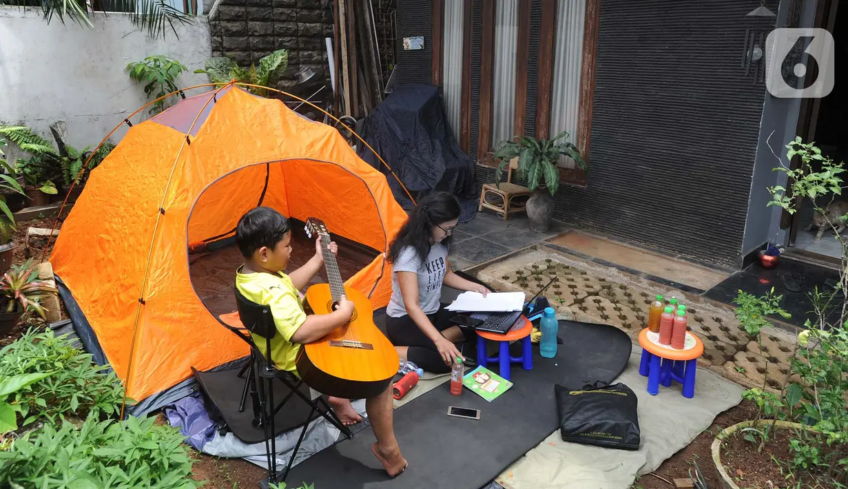 Aktivitas warga saat work from home di halaman rumahnya di kawasan Cinere, Depok, Senin (23/3/2020). Imbauan pemerintah untuk bekerja dari rumah atau work from home untuk mencegah penularan virus corona, dimanfaatkan warga dengan beragam aktivitas. (merdeka.com/Arie Basuki)