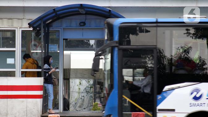 Pengguna bus Transjakarta menggunakan masker di halte kawasan Kuningan, Jakarta, Rabu (27/5/2020). Empat provinsi di Indonesia termasuk DKI Jakarta akan mulai melakukan persiapan menuju new normal atau tatanan kehidupan baru menghadapi COVID-19. (Liputan6.com/Helmi Fithriansyah)