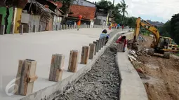 Pekerja menyiapkan alat untuk pembangunan jalan inspeksi Sungai Ciliwung di Cililitan Kecil, Jakarta, Kamis (22/12). Pembangunan jalan tersebut sebagai salah satu solusi mengatasi kemacetan di Ibukota (Liputan6.com/Gempur M Surya)