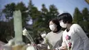 Pengunjung mempersembahkan bunga di altar darurat untuk berduka bagi korban gempa bumi dan tsunami 11 Maret 2011 di Tokyo, Jumat (11/3/2022). Jepang menandai peringatan 11 tahun gempa bumi, tsunami dan bencana nuklir yang melanda pantai timur laut Jepang. (AP Photo/Eugene Hoshiko)