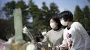 Pengunjung mempersembahkan bunga di altar darurat untuk berduka bagi korban gempa bumi dan tsunami 11 Maret 2011 di Tokyo, Jumat (11/3/2022). Jepang menandai peringatan 11 tahun gempa bumi, tsunami dan bencana nuklir yang melanda pantai timur laut Jepang. (AP Photo/Eugene Hoshiko)