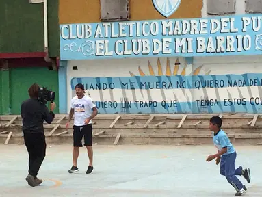 Bintang sepak bola David Beckham bermain sepak bola bersama anak-anak di kawasan pemukiman kumuh 1-11-14 di Buenos Aires, Senin (9/11/2015). Beckham berada Argentina untuk membuat film dokumenter tentang sepak bola. (AFP/FIXER-Argentina/Macarena GAGLIARD)