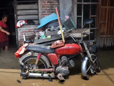 Warga berada di rumahnya yang tergenang banjir di kawasan Sawah besar Semarang, Jawa Tengah, Sabtu (8/12). Ratusan rumah tergenang banjir akibat Tanggul Sungai Banjir Kanal Timur jebol. (Liputan6.com/Gholib)