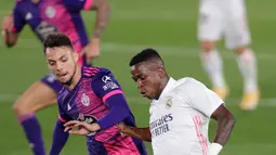 Penyerang Real Madrid, Vinicius Junior  pemain Valladolid, Oscar Plano pada lanjutan La Liga Spanyol di stadion Alfredo, Rau (30/9/2020). Real Madrid menekuk Real Valladolid denga skor 1-0. (AP Photo/Manu Fernandez)