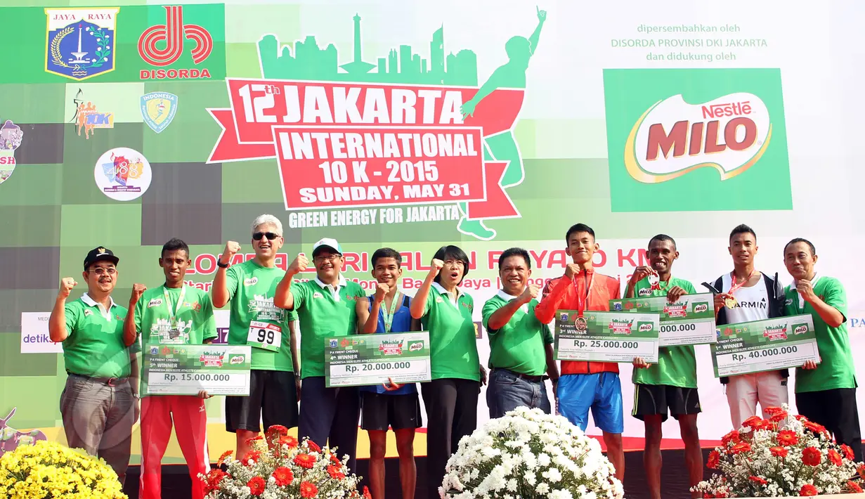 Wagub DKI Djarot Saiful (keempat kiri) dan juara Jakarta International 10K 2015 kategori elit nasional putra, Jauhari Johan (kedua kanan) berfoto bersama seusai penyerahan hadiah di Silang Monas,  Jakarta, Minggu (31/5). (Liputan6.com/Helmi Afandi)