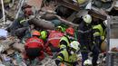 Petugas pemadam kebakaran mencari korban dari puing-puing bangunan yang runtuh di Sanary-sur-Mer, Prancis, 7 Desember 2021. Satu orang tewas dan dua lainnya masih dinyatakan hilang setelah gedung apartemen tiga lantai runtuh akibat ledakan gas. (NICOLAS TUCAT/AFP)