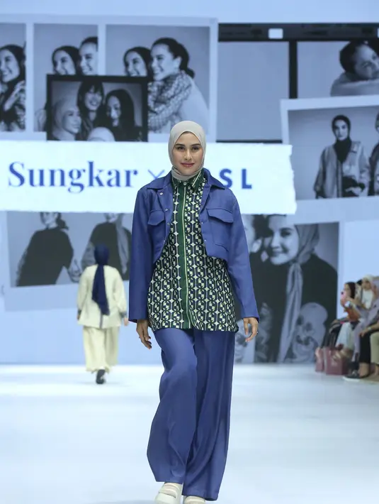 Syahnaz Sadiqah juga turut tampil sebagai model untuk Zaskia Sungkar x NASL. Ia mengenakan kerudung abu-abu yang dipadukan dengan crop outer berwarna navy yang memiliki kantong, serasi dengan celana panjangnya. Di bawah outer, ia mengenakan inner berupa kemeja bermotif hijau. [Dok/Fimela/Adrian Utama P].