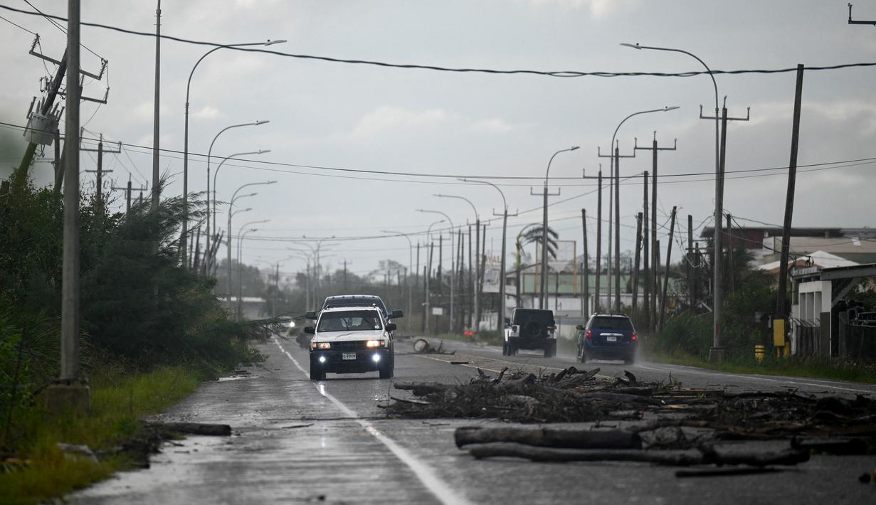 Cabang-cabang pohon terlihat tumbang di jalan setelah Badai Lisa di Belize City, Belize, 3 November 2022. Badai Tropis Lisa menyebabkan banjir dan membuat sebagian negara itu menjadi gelap gulita. (Johan ORDONEZ/AFP)
