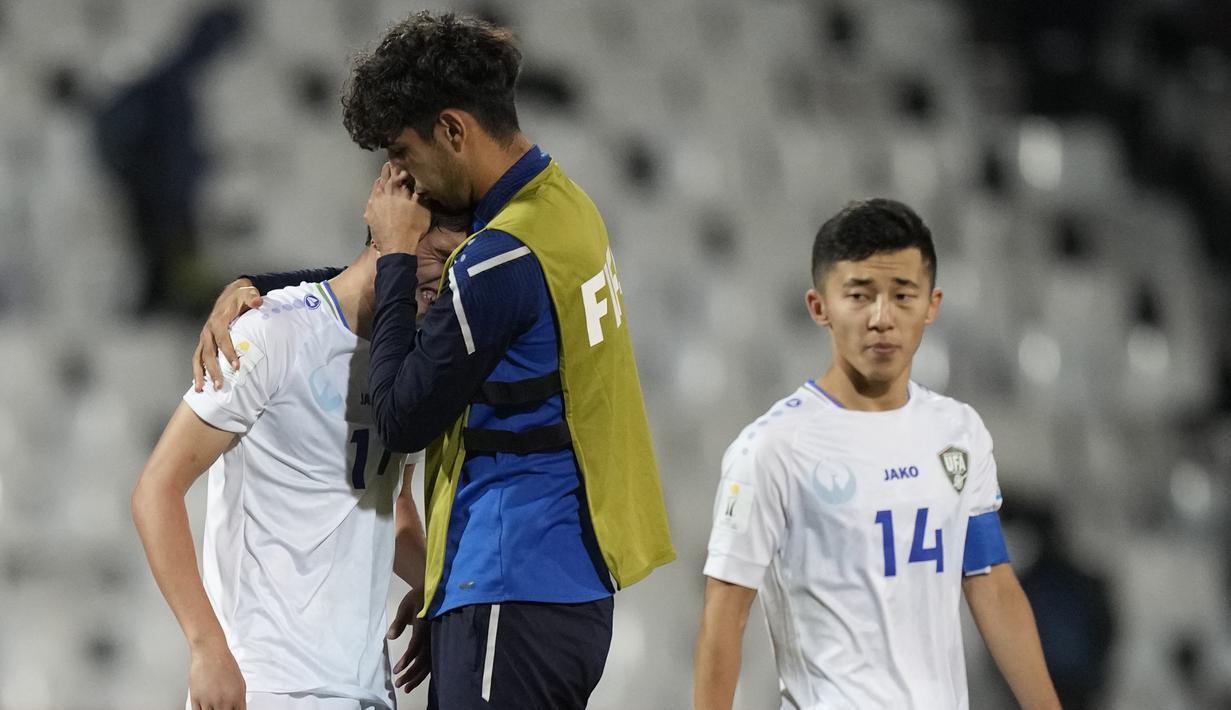 Gelandang Timnas Uzbekistan U-20, Nodirbek Abdurazzokov dihibur rekannya setelah dikalahkan Israel pada laga babak 16 besar Piala Dunia U-20 2023 di Malvinas Argentinas Stadium, Mendoza, Argentina, Rabu (31/5/2023) dini hari WIB. (AP Photo/Ricardo Mazalan)
