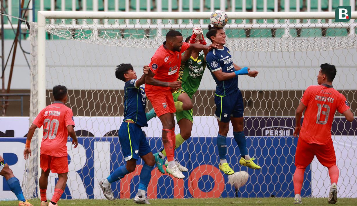 Pemain Persib Bandung, Achmad Jufriyanto (tengah) menghalau bola di udara dari pemain Borneo FC dalam pertandingan lanjutan BRI Liga 1 2022/2023 yang berlangsung di Stadion Pakansari, Bogor, Kamis (26/1/2023). (Bola.com/Ikhwan Yanuar)
