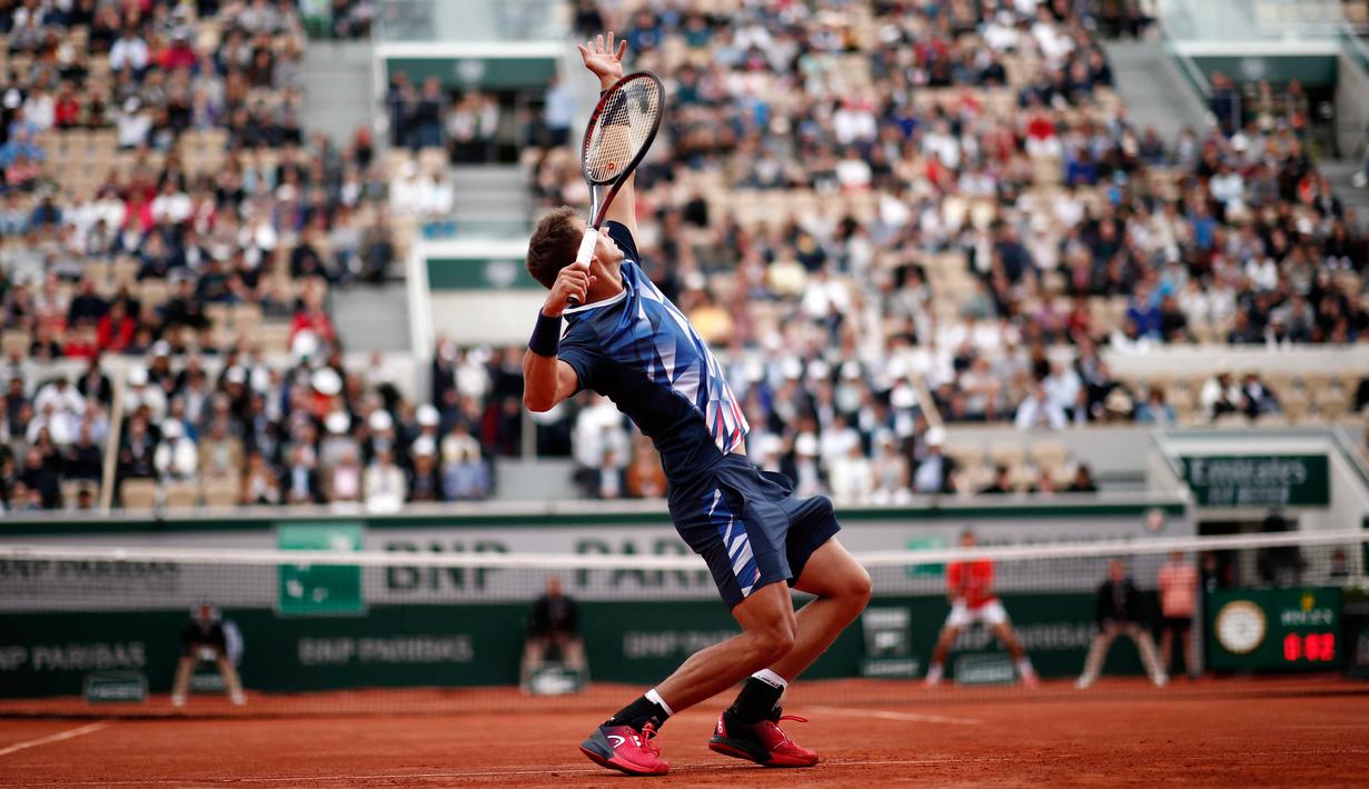 Petenis Swiss, Henri Laaksonen memukul bola ke arah lawannya petenis Serbia, Novak Djokovic pada putaran kedua Prancis Terbuka 2019 di Stadion Rolland Garros, Kamis (30/5/2019). Novac Djokovic berhasil melaju ke babak ketiga setelah mengandaskan Henri Laaksonen 6-1, 6-4 6-3. (REUTERS/Benoit Tessier)
