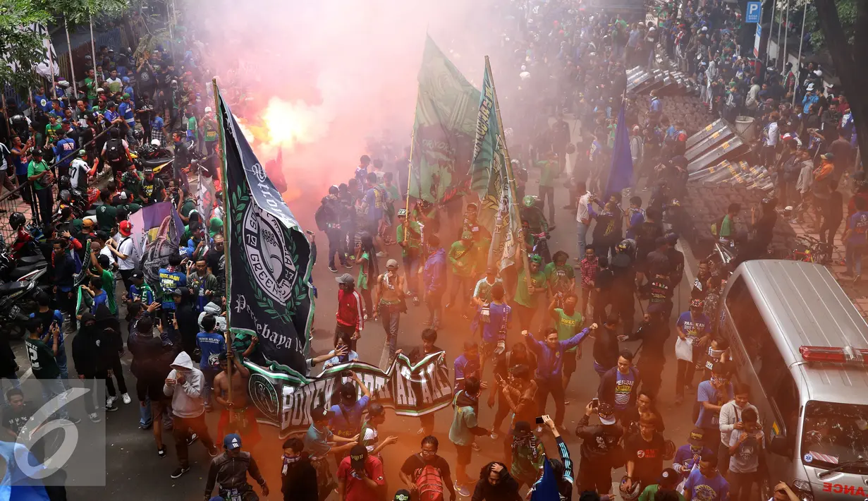 Pendukung Persebaya menyalakan suar di ruas jalan Padjajaran saat merayakan kembalinya klub mereka ke kompetisi PSSI, Bandung, Minggu (8/1). Berdasar putusan Kongres PSSI 2017, Persebaya 1927 kembali ke divisi utama. (Liputan6.com/Helmi Fithriansyah)