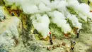 Di balik hijaunya pegunungan Jawa Timur, Kawah Ijen juga menyimpan fenomena geologi yang luar biasa. Gunung Ijen terbentuk dari serangkaian letusan besar sekitar 3.500 tahun lalu. Berdasarkan data Kementerian Energi dan Sumber Daya Mineral, letusan tersebut menciptakan kaldera raksasa dengan diameter mencapai sekitar 25 kilometer. Di dalam kaldera inilah terbentuk danau kawah yang kini menjadi pusat aktivitas vulkanik Gunung Ijen. Tampak dalam foto, aktivitas penambang tradisional menambang bongkahan belerang dari dasar kawah Ijen di Banyuwangi, Jawa Timur. (merdeka.com/Arie Basuki)