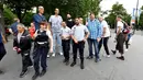 Arshavir Grigoryan dari Armenia (2,33 meter) dan Brahim Takioullah dari Prancis (2,46) berpose dengan aparat kepolisian di Champs-Elysees Avenue, Paris, 1 Juni 2018. Belasan pria tertinggi di dunia bertemu pada akhir pekan di Paris. (AFP/GERARD JULIEN)