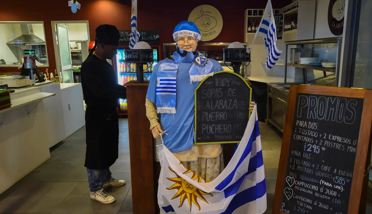 Bendera Uruguay dipajang di sebuah bar di Montevideo (4/7). Warga Uruguay antusias mempersiapkan untuk mendukung negaranya bertanding melawan Prancis pada babak 8 besar Piala Dunia 2018 di Rusia. (AFP Photo/Miguel Rojo)