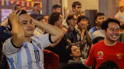 Reaksi kecewa pendukung Argentina saat nobar laga final Piala Dunia 2022 bersama Federal Oil yang berlangsung di daerah Kemang, Jakarta Selatan, Minggu (18/12/2022) malam WIB. Argentina berhasil mengalahkan Prancis melalui babak penalti dengan skor 4-2. (Bola.com/Muhammad Aldiansyah)