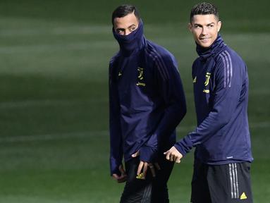 Pemain Juventus, Cristiano Ronaldo, bersama Mehdi Benatia saat latihan di Stadion Allianz, Turin, Senin (26/11). Latihan ini persiapan jelang laga Liga Champions melawan Valencia. (AFP/Marco Bertorello)