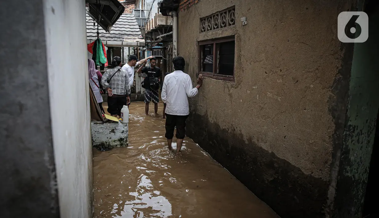Aktivitas warga saat banjir di kawasan Rawajati, Kalibata, Jakarta, Senin (10/10/2022). Tingginya curah hujan di kawasan Bogor mengakibatkan ratusan rumah di enam RT Kelurahan Rawajati terendam banjir dengan ketinggian mencapai dua meter. (Liputan6.com/Faizal Fanani)