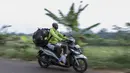 Pesepak bola legendaris, Alexander Pulalo, mengendarai motor usai melatih di SSB Parung, Jawa Barat, Jumat (13/7/2018). Pemain kelahiran Papua ini merupakan mantan anggota PSSI Primavera. (Bola.com/Vitalis Yogi Trisna)