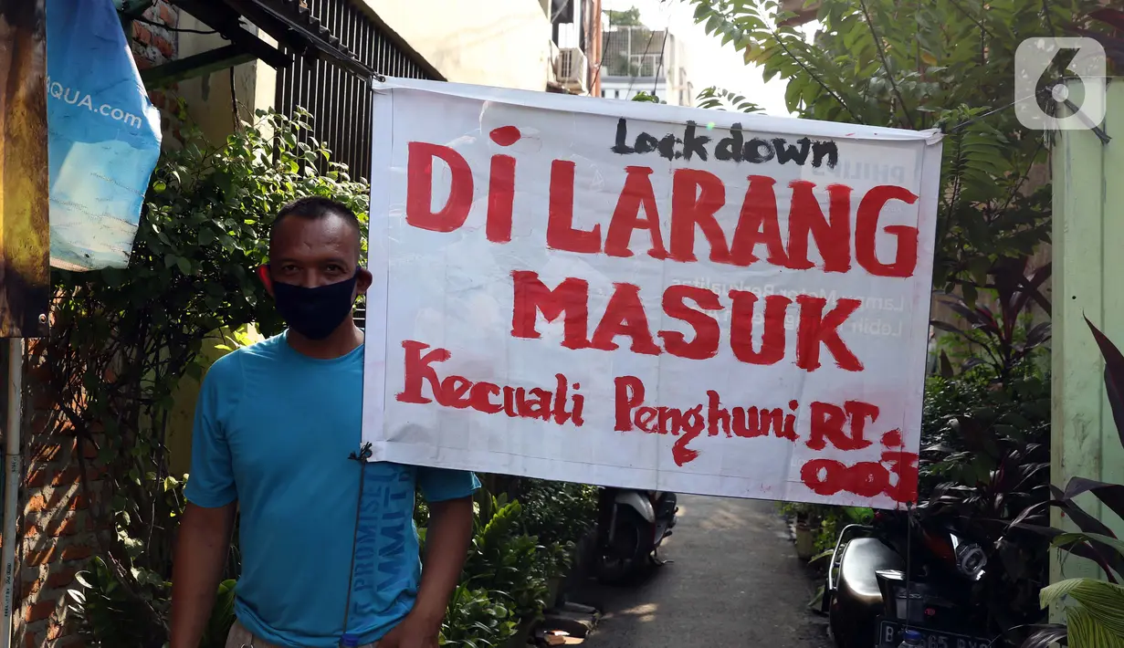 Warga berjalan di salah satu gang yang ditutup secara mandiri di kawasan Tambora, Jakarta, Sabtu (4/4/2020). Penutupan akses masuk kawasan ini untuk membatasi kegiatan warga dan mencegah penyebaran serta penularan virus COVID-19. (Liputan6.com/Helmi Fithriansyah)