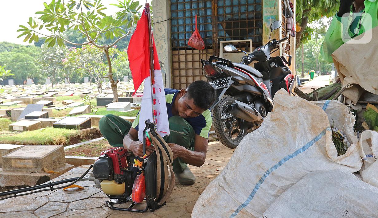 Petugas Pertamanan dan Kehutanan Kota Jakarta Pusat menyiapkan mesin potong rumput di TPU Karet Bivak, Jakarta, Minggu (16/8/2020). Dalam rangka menyambut HUT ke-75 RI, para petugas bekerja dengan mengenakan atribut kemerdekaan. (Liputan6.com/Herman Zakharia)