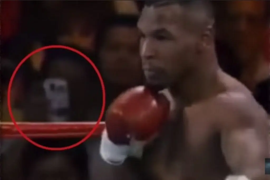 Di dalam foto tersebut, terlihat seorang pria sedang merekam pertandingan tinju Mike Tyson versus Peter McNeely, menggunakan smartphone-nya (komando.com).