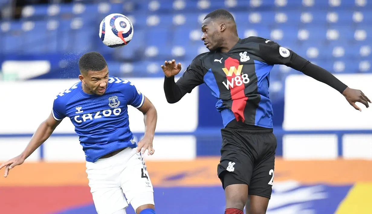 Bek Everton, Mason Holgate  berebut bola dengan penyerang Crystal Palace, Christian Benteke pada pekan ke-30 Liga Inggris di Goodison Park, Selasa (6/4) dini hari WIB. Duel Everton vs Crystal Palace harus berakhir imbang dengan skor 1-1. (Peter Powell / Pool via AP)