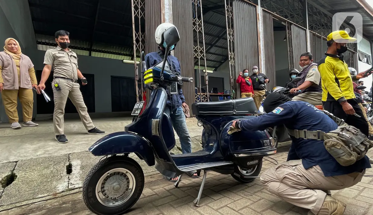Petugas melakukan uji emisi kendaraan motor vespa di Laboratorium Tanah dan Jalan Dinas Bina Marga, Jakarta Timur, Rabu (17/11/2021). Uji emisi yang dilakukan ini merupakan salah satu cara untuk mengurangi pencemaran udara dan dampak negatif pencemaran lingkungan. (merdeka.com/Imam Buhori)