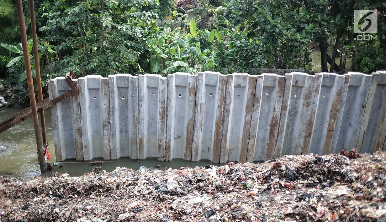 Tiang pancang turap aliran anak kali ciliwung yang terbengkalai di kawasan Jalan Gudang Air, Jakarta, Selasa (12/2).Pengerjaan yang tak kunjung selesai menyebabkan jalan hadidji dan sekitar kerap banjir jika hujan deras.(Liputan6.com/Faizal Fanani)
