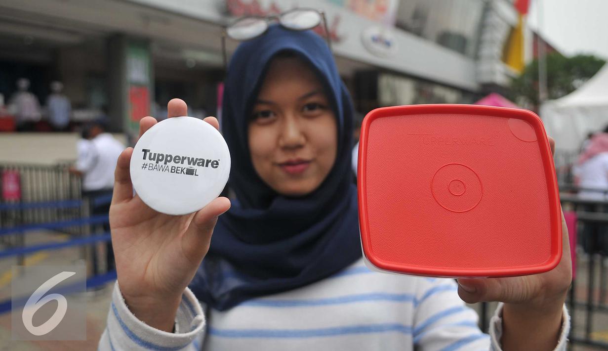 Pengunjung memperlihatkan Tupperware, Jakarta, Selasa (12/4).2500 Tupperware dibagikan secara gratis sebagai dukungan untuk membangun pola hidup sehat, hemat, dan ramah lingkungan melalui kebiasaan membawa bekal. (Liputan6.com/Gempur M Surya)