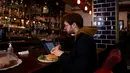 Seorang pria makan di samping laptopnya di sebuah kafe di Beirut pada 14 Januari 2022. Kafe-kafe Beirut sekarang berfungsi sebagai tempat kerja pengganti bagi orang-orang yang bergulat dengan kekurangan listrik dan pemutusan internet yang berasal dari krisis ekonomi. (JOSEPH EID / AFP)
