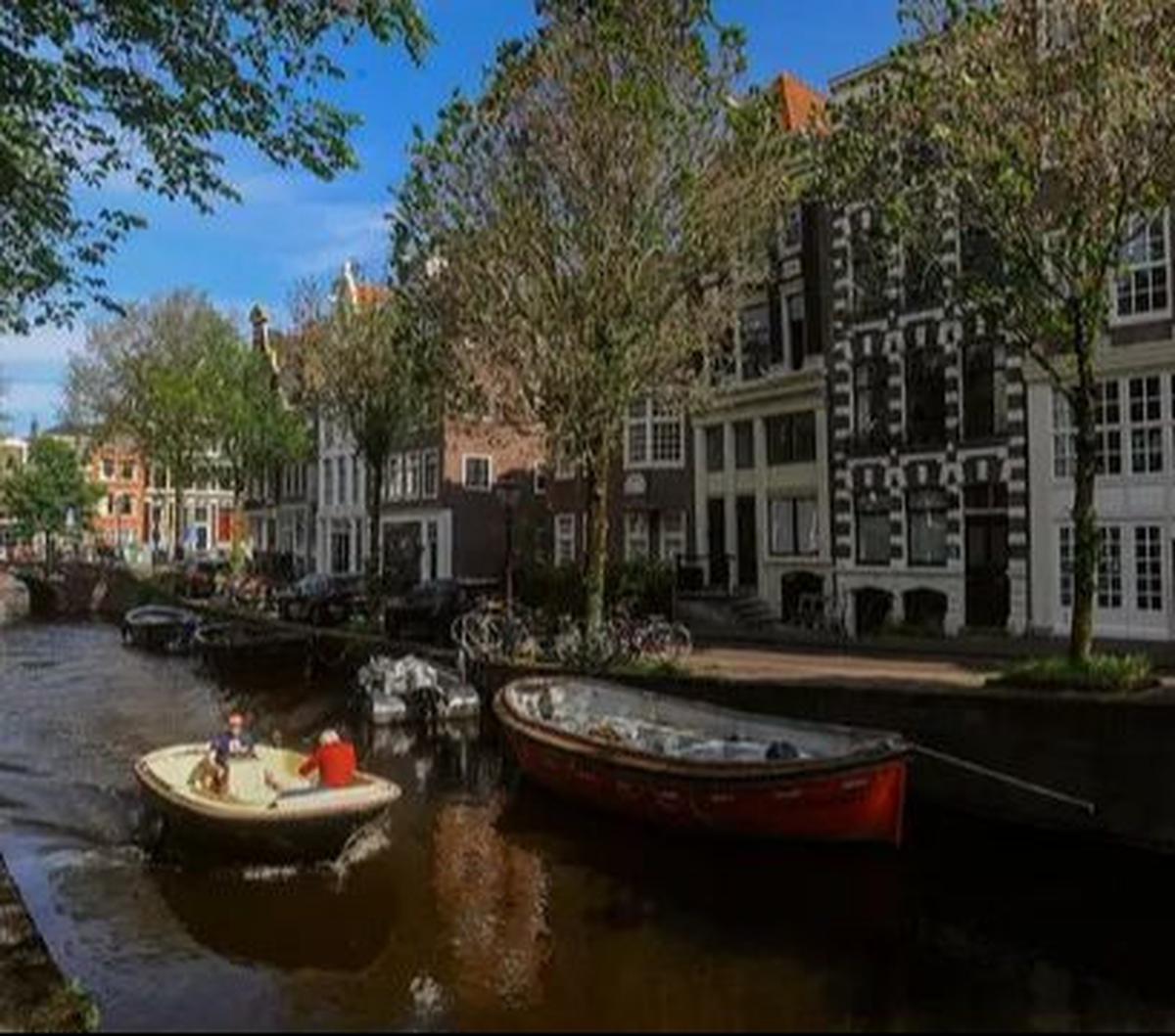 Sebuah kapal berlayar melewati kanal di kota Amsterdam, Belanda, Selasa (22/05/2024).&nbsp;Amsterdam dikenal di seluruh dunia karena kanal-kanalnya yang indah melintasi kota. Merdeka.com/Arie Basuki