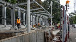 Sejumlah pekerja menyelesaikan pembangunan selter di kawasan Stasiun Palmerah, Jakarta, Selasa (2/2/2021). Penataan kawasan Stasiun Palmerah mencakup pembangunan selter untuk bus, angkot, dan ojek online. (Liputan6.com/Faizal Fanani)