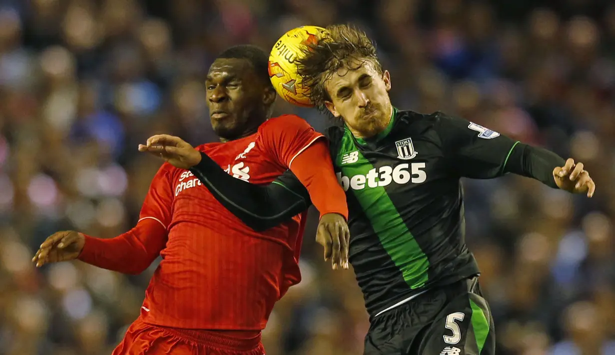 Pemain Liverpool, Christian Benteke (kiri), duel dengan pemain Stoke City, Marc Muniesa, dalam leg kedua semifinal Piala Liga Inggris di Stadion Anfield, Liverpool, Rabu (26/1/2016) dini hari WIB. (Reuters/Phil Noble)