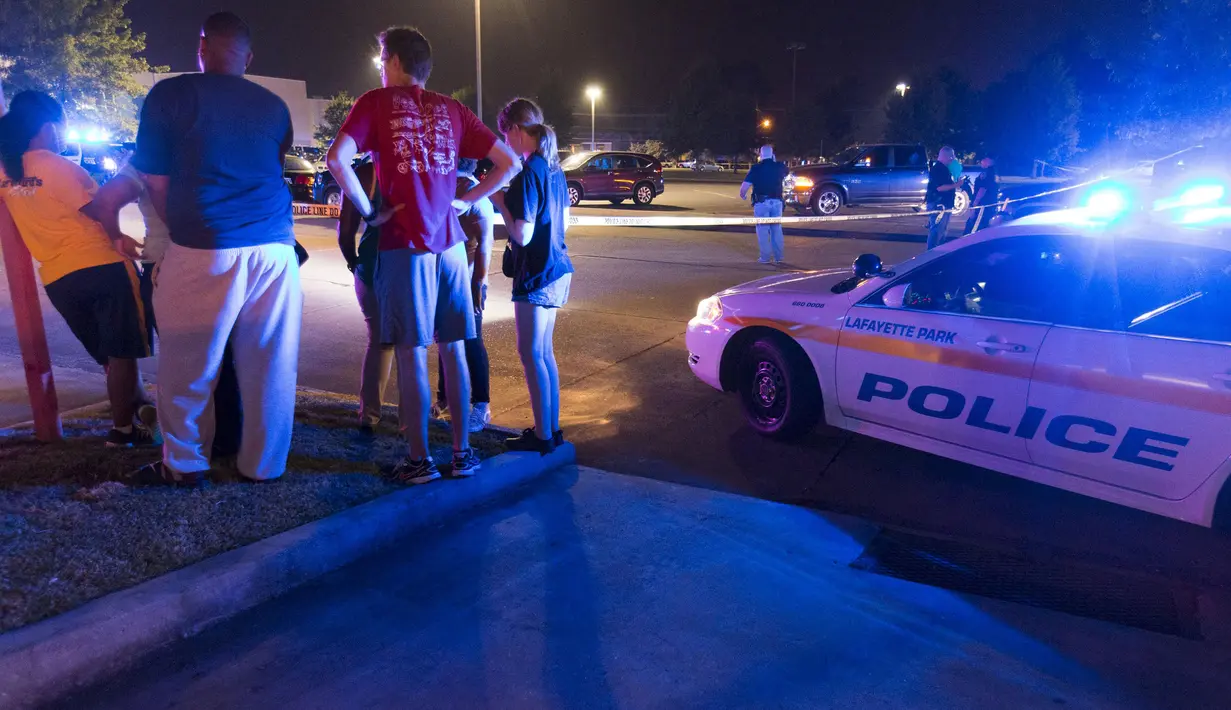 Sejumlah warga menunggu kabar di luar gedung bioskop Lafayette, Louisiana, AS, Kamis (23/7/ 2015). Pria bersenjata  melepaskan tembakan pada Kamis malam  yang  menewaskan dua orang dan melukai tujuh orang lainnya.(REUTERS/Lee Celano)