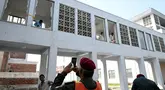 Para pekerja menyingkirkan pecahan kaca jendela setelah insiden kebakaran di luar bangsal Kesehatan Ibu dan Anak (MCH) di Rumah Sakit Pakistan Institute of Medical Sciences (PIMS), Islamabad, Pakistan, Rabu, 26 Agustus 2026. (AFP/  Aamir Qureshi)