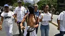 Aksi seorang wanita bertelanjang dada saat berunjuk rasa menentang Presiden Venezuela Nicolas Maduro di Caracas, Sabtu (6/5). Secara keseluruhan, aksi protes massal menentang Maduro telah berlangsung lebih dari satu bulan. (AFP PHOTO / FEDERICO PARRA)