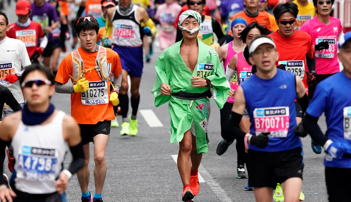 Pelari berkostum tradisional melintas di distrik perbelanjaan Ginza saat ambil bagian dalam Tokyo Marathon 2018 , Minggu (25/2). Tokyo Marathon merupakan ajang bergengsi lari kelas dunia yang diikuti pelari dari berbagai negara. (AP/Shizuo Kambayashi)