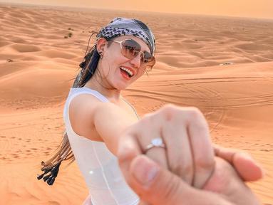 Via Vallen saat menggandeng tangan sang suami Chevra Yolandi, terlihat Via Vallen kedapatan memakai cincin kawinnya di jari manisnya. Pelantun lagu Sayang itu tampak bahagia saat bersama suaminya di gurun pasir. (Instagram/viavallen)