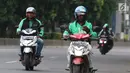 Pengemudi ojek online mengoperasikan telepon seluler sambil mengendarai sepeda motor di Jalan Gatot Subroto, Jakarta, Kamis (8/3). Polisi menilai tindakan itu membahayakan karena  pengemudi menjadi tidak fokus di jalan raya. (Liputan6.com/Arya Manggala)