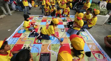 Anak-anak bermain ular tangga pada acara Kampanye Nasional bertajuk Cegah Stunting Itu Penting di Lapangan Gasibu, Bandung, Minggu (18/11). Kampanye bersama Energen menunjukkan kepedulian terhadap kasus balita bertubuh pendek. (Liputan6.com/HO/Bon)