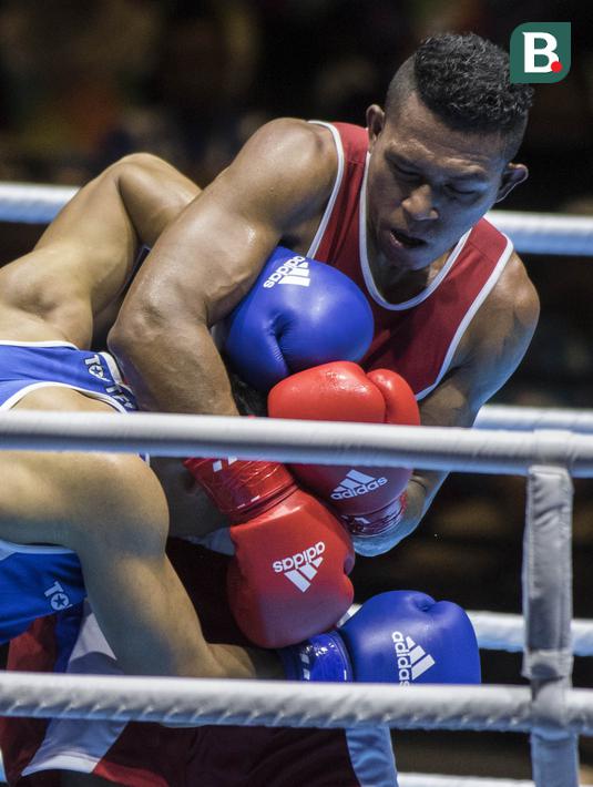Petinju Indonesia, Brama Betaubun, menahan petinju Taiwan, Chia-Wei Kan, pada Invitation Tournament Asian Games di JiExpo Kemayoran, Jakarta, Senin (12/2/2018). Petinju Indonesia kalah 1-4 dari petinju Taiwan. (Bola.com/Vitalis Yogi Trisna)