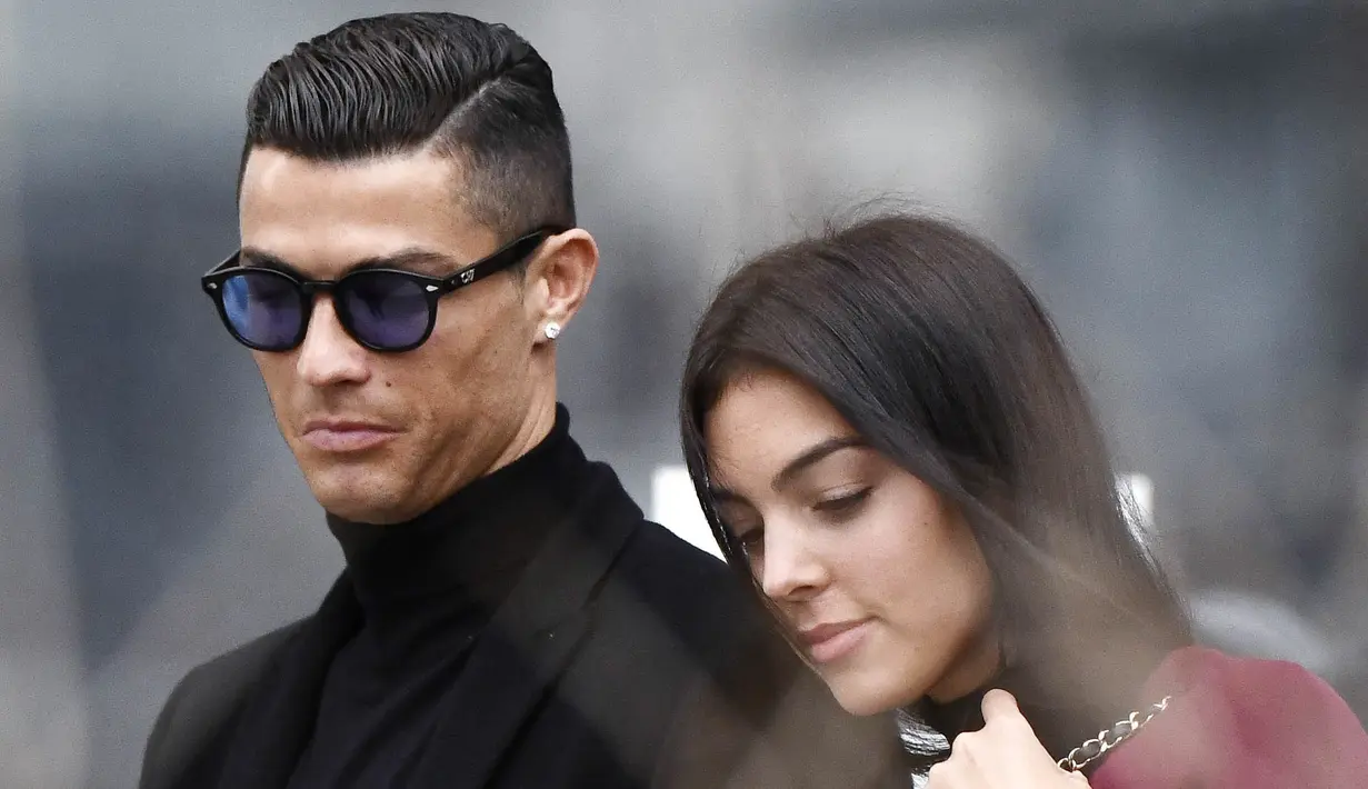 Cristiano Ronaldo bersama kekasihnya, Georgina Rodriguez, meninggalkan kantor pengadilan usai menghadiri sidang penggelapan pajak di Madrid, Spanyol (22/2/2019). (AFP/Oscar Del Pozo)