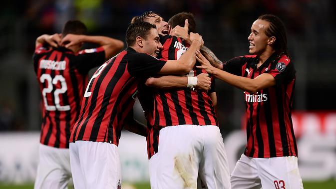 Pemain AC Milan saling berpelukan usai menaklukkan AS Roma dalam Serie A Italia di Stadion San Siro, Milan, Jumat (31/8). (MARCO BERTORELLO/AFP)