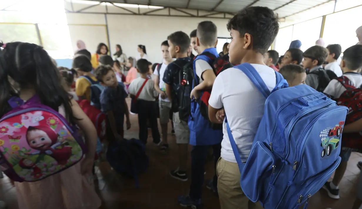 Anak-anak sekolah berbaris di sebuah sekolah swasta di Birkhadem, di luar Aljazair, Rabu (21/9/2022). Menurut keputusan presiden, bahasa Inggris akan menjadi bahasa asing kedua yang diajarkan di tingkat dasar, bersama dengan bahasa Prancis. (AP Photo/Fateh Guidoum)