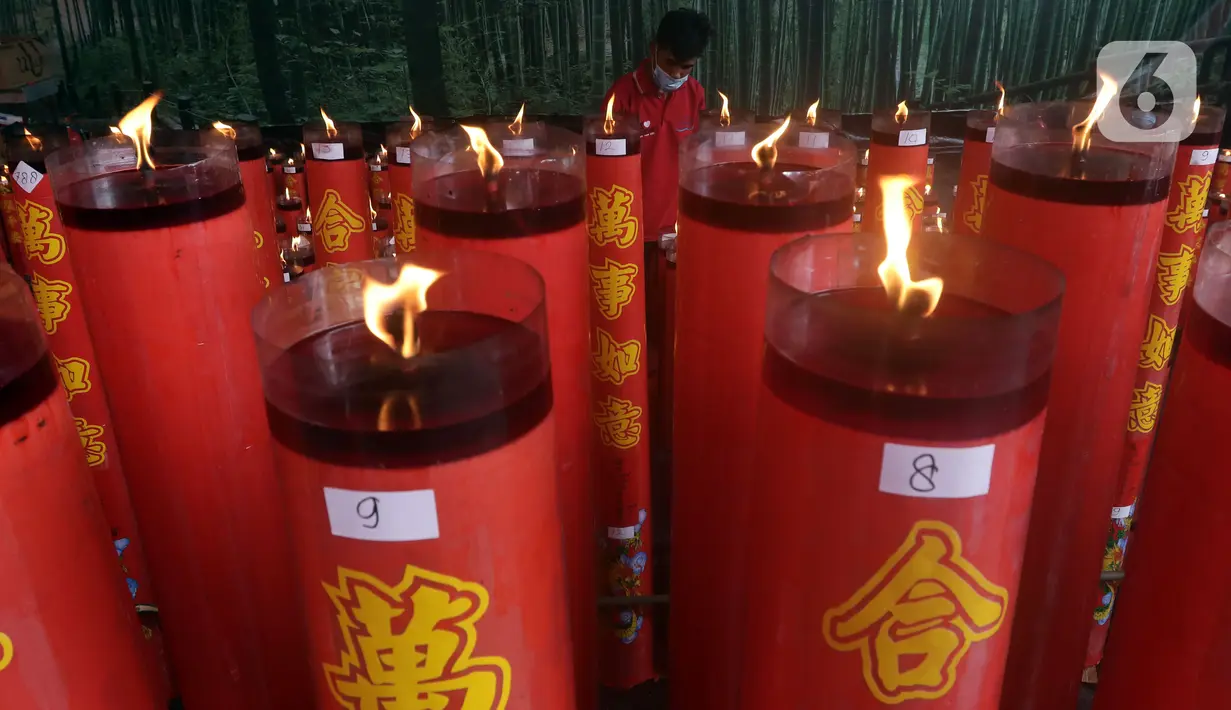 Pekerja merapikan lilin saat perayaan Tahun Baru Imlek 2573 di Vihara Dhanagun, Kota Bogor, Selasa (1/2/2022). Pelaksanaan ibadah Tahun Baru China atau Imlek 2573 di Kota Bogor berjalan secara khidmat dan aman. (Liputan6.com/Helmi Fithriansyah)