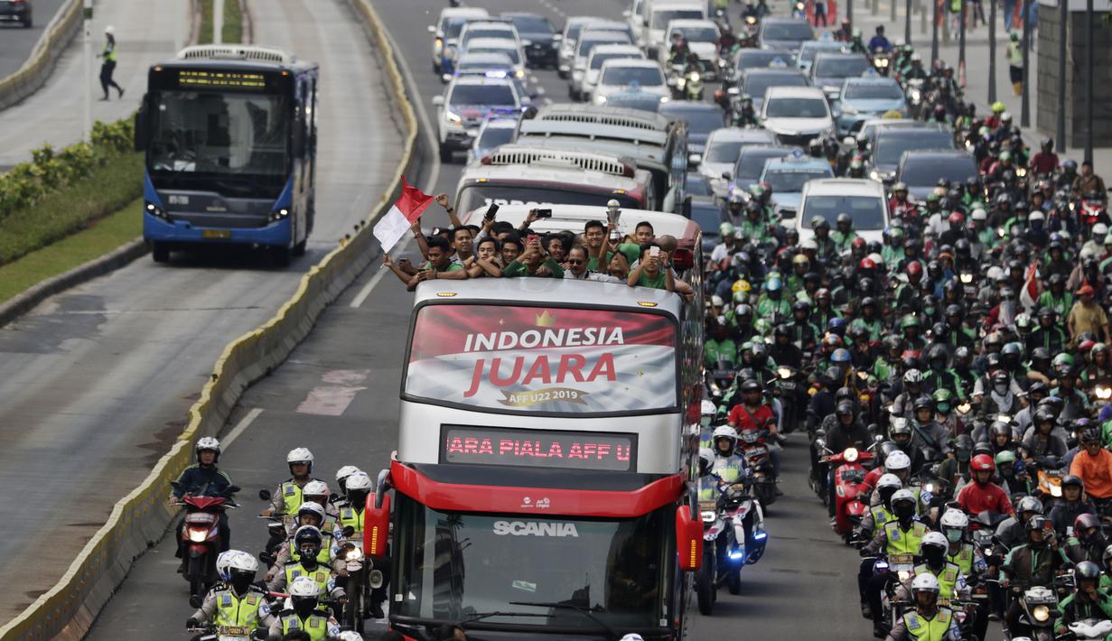 Pemain dan ofisial Timnas Indonesia U-22 menaiki bus tingkat saat konvoi menuju Istana Negara Jakarta, Kamis (28/2). Pawai tersebut untuk merayakan keberhasilan skuat Garuda Muda menjuarai Piala AFF U-22 di Kamboja. (Bola.com/M Iqbal Ichsan)