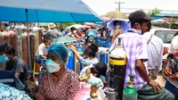 Orang-orang mengantre di sebelah tabung oksigen untuk diisi ulang di luar pabrik oksigen Naing di kawasan industri South Dagon di Yangon, Myanmar, Rabu (28/7/2021). Myanmar saat ini dilanda lonjakan jumlah kasus COVID-19 dan kematian yang sangat membebani infrastruktur medis negara itu. (AP Photo)